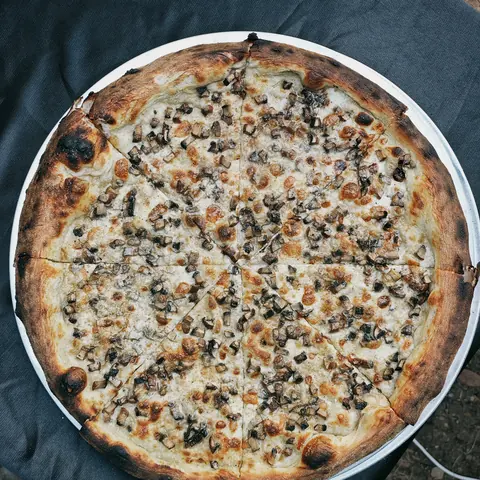burnt. white sourdough pizza with mushrooms, top view